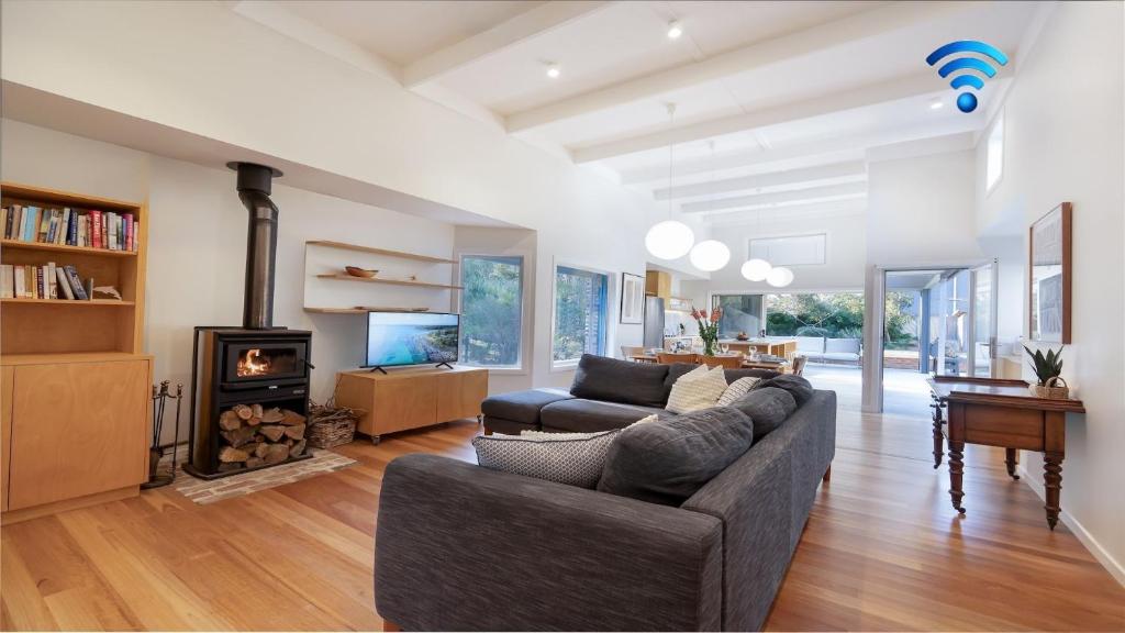 a living room with a couch and a fireplace at Buwarla House in Currarong