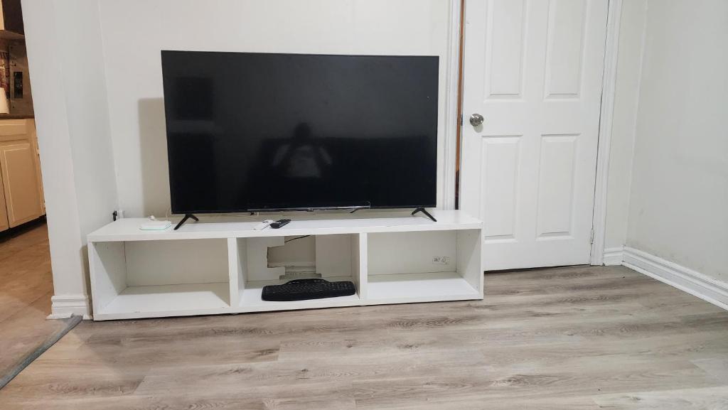 a television on a white entertainment center in a room at Guest suite with great comfort in Brampton