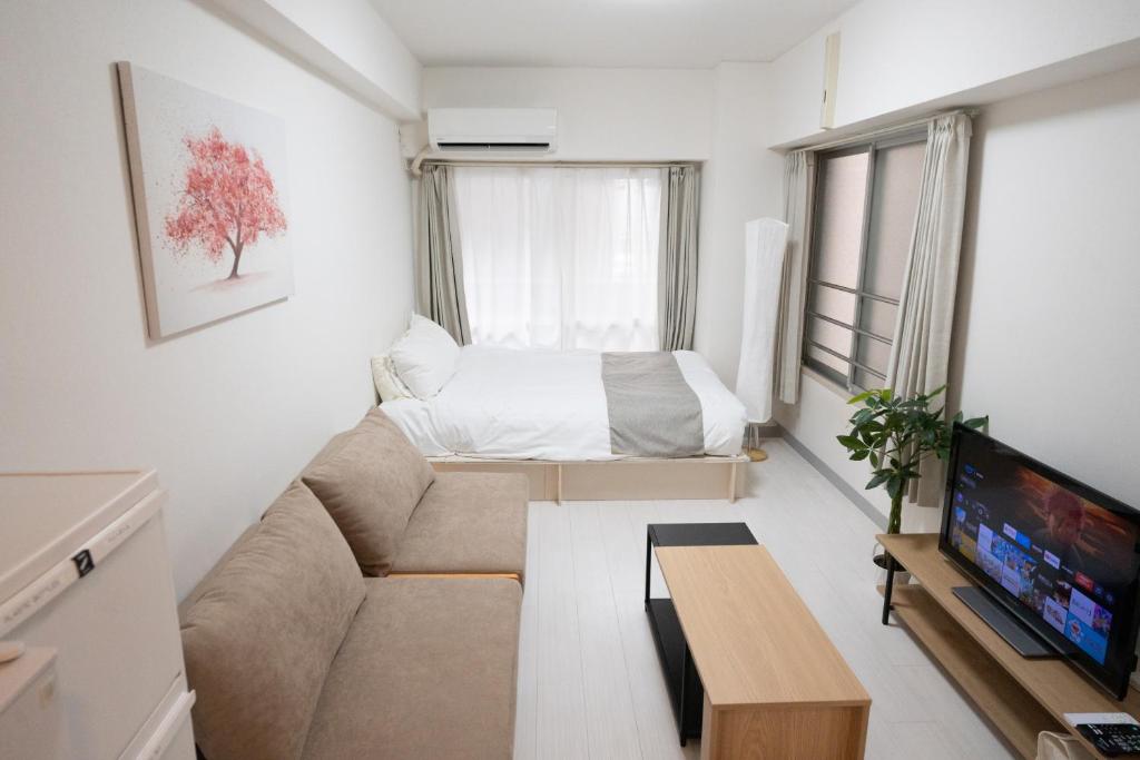 a living room with a couch and a bed at Park building Tenmonkan 1 in Kagoshima