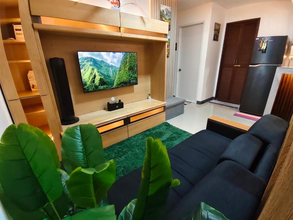 a living room with a tv and a blue couch at Balay Madayaw in Davao City