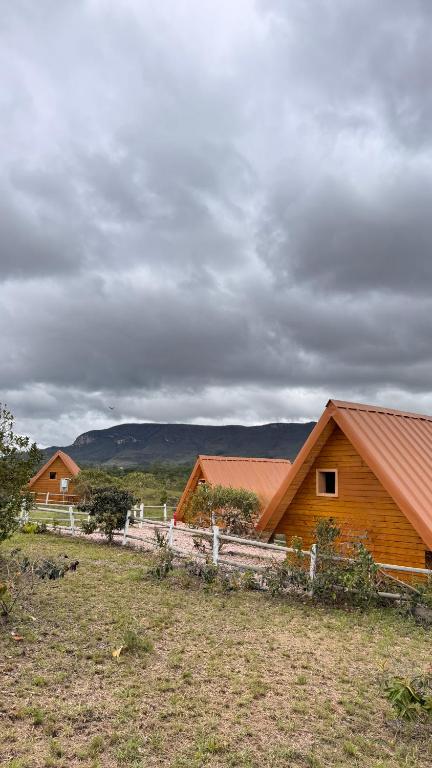 a group of wooden houses in a field at CÉU DE AGARTHA Retiros e Vivências in Alto Paraíso de Goiás