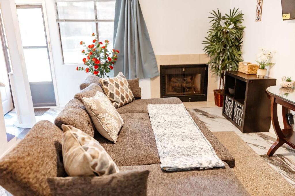 a living room with a couch and a fireplace at The Huntsville Nest - 2BR Near SHSU - Pool - WiFi - Free Parking in Huntsville