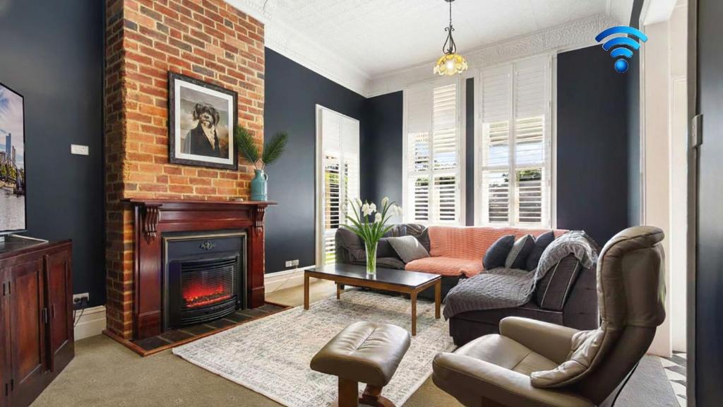 a living room with a couch and a fireplace at Charming Heritage Retreat in Sale
