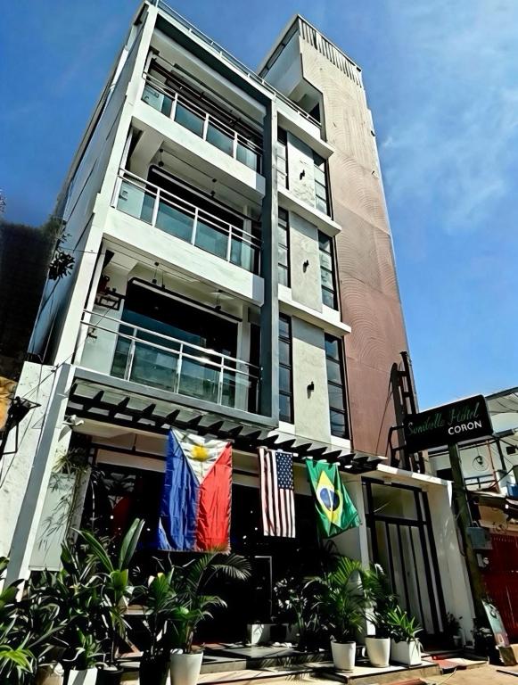 ein hohes Gebäude mit Flaggen davor in der Unterkunft Sanibelle Hotel in Coron