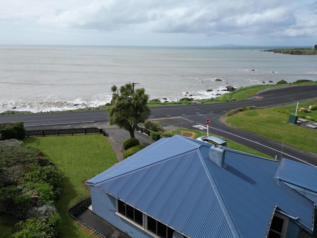 an overhead view of a blue house and the ocean at Justavacation Beachfront Bach in Riverton