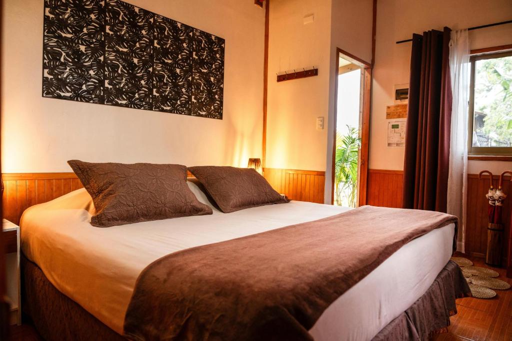 a bedroom with a large bed and a window at PARAÍSO Sunset Bungalows in Hanga Roa