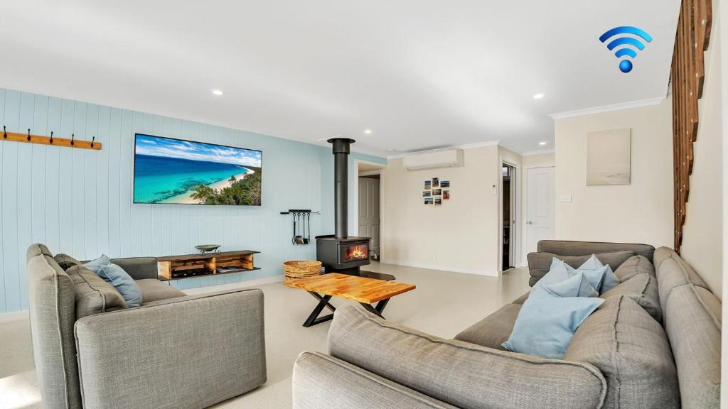 a living room with two couches and a fireplace at The Loft in Culburra Beach