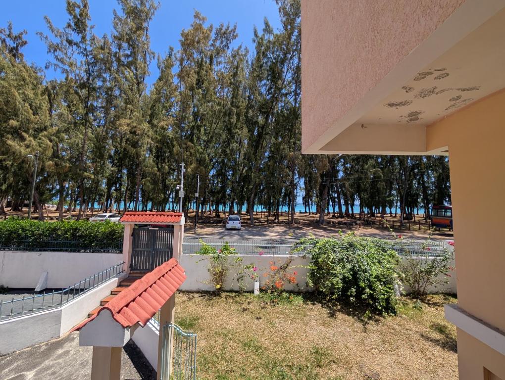 a bench on the side of a building with a parking lot at Beachfront 4-Bedroom Villa with Rooftop Sunset Terrace in Flic-en-Flac