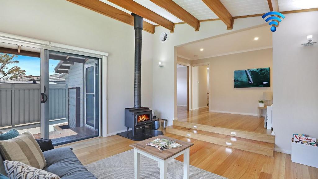 a living room with a fireplace and a couch at Coastal Bungalow in Callala Bay