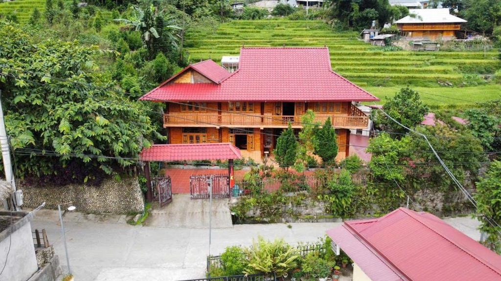 a large wooden house with a red roof at My's Hmong House in Tả Van