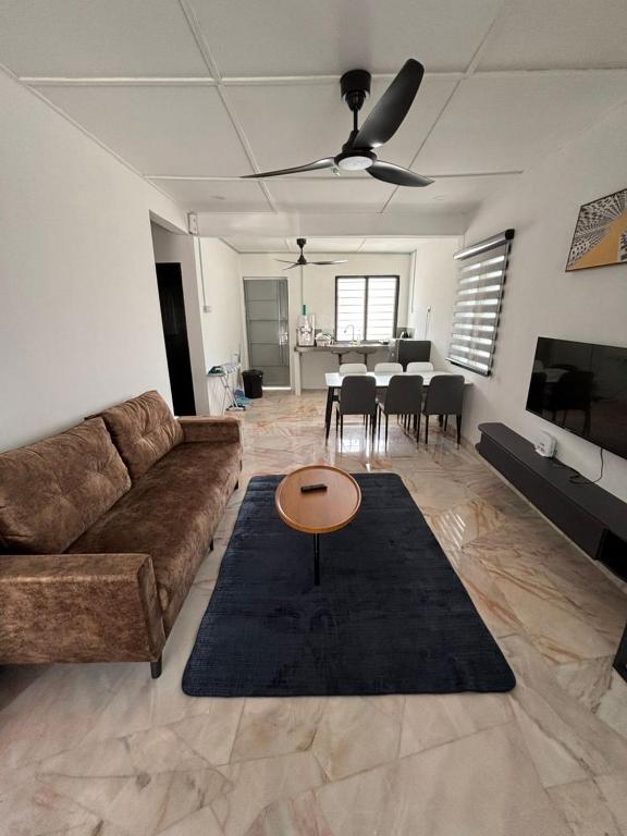 a living room with a couch and a table at KH Homestay in Kampong Batu Lapan