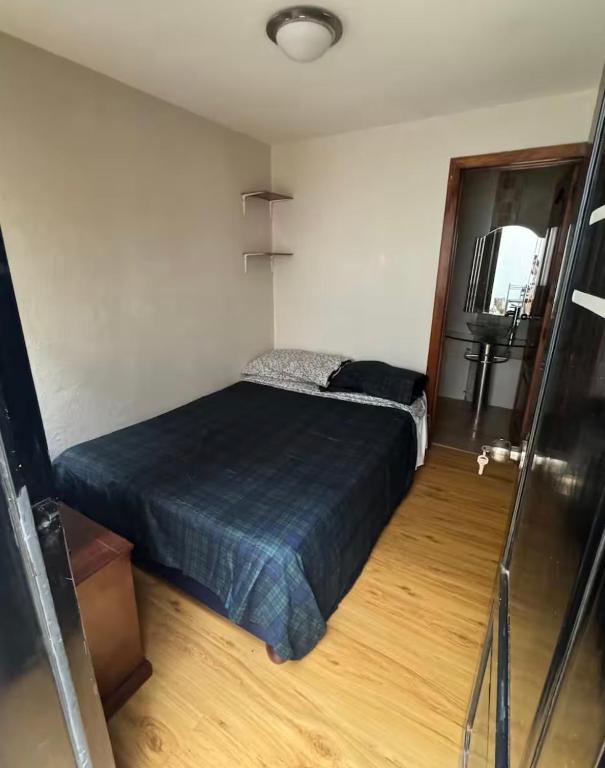 a bedroom with a bed with a blue bedspread at Or mini habitación in Cuenca
