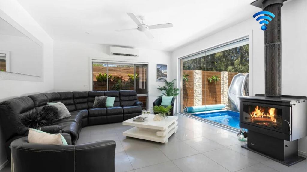 a living room with a couch and a fireplace at Marine Adventures in Callala Bay