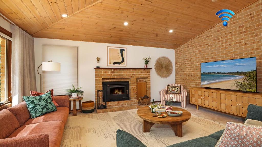 a living room with a couch and a fireplace at Coolburra in Culburra Beach
