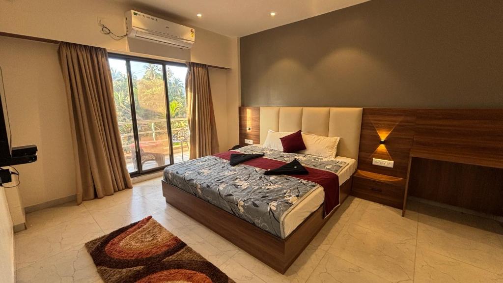 a bedroom with a bed and a large window at Shrileela Beach Resort in Murūd