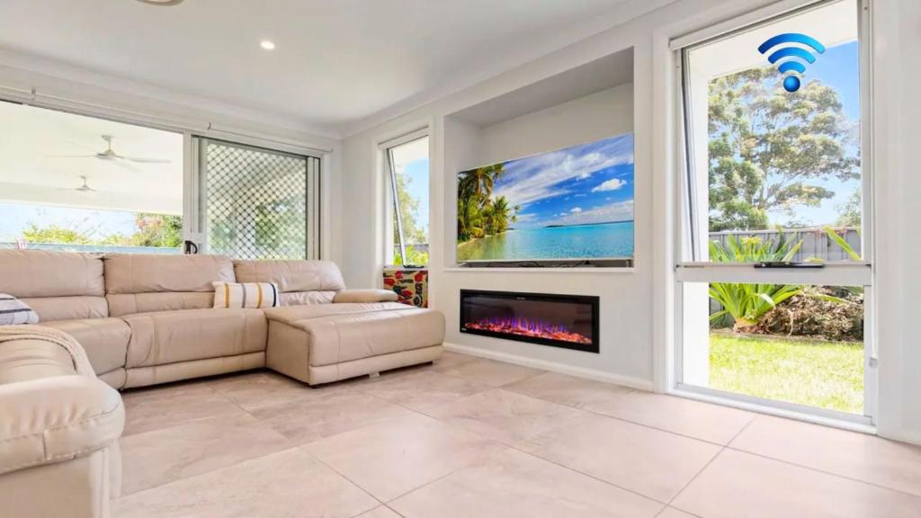 a living room with a couch and a fireplace at Pollys in Callala Bay