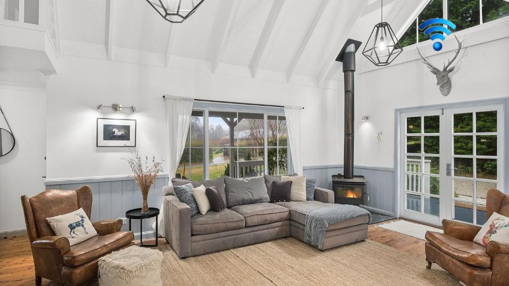 a living room with a couch and a fireplace at Dove Cottage in Bundanoon