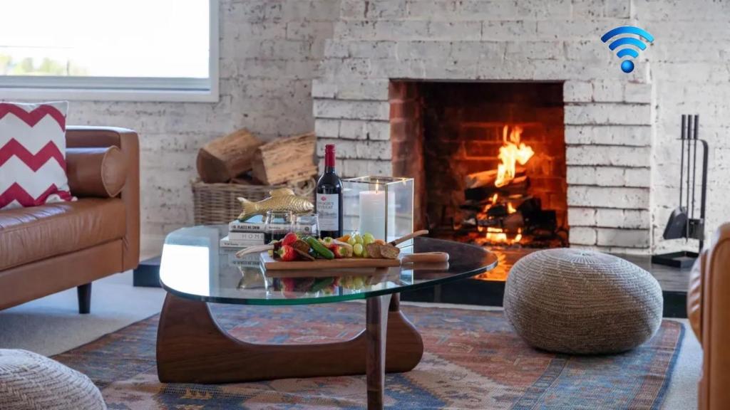 a living room with a table and a fireplace at Halcyon in Kiama