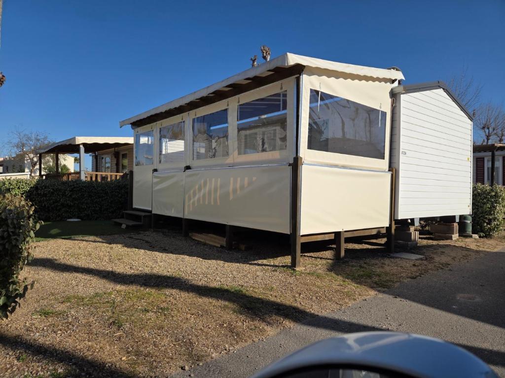 a small white train car sitting in a yard at FMLODGE mobil home le petit cocon in Valras-Plage