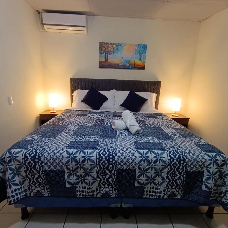 a bedroom with a bed with a blue and white quilt at Hotel Sueños in San Salvador