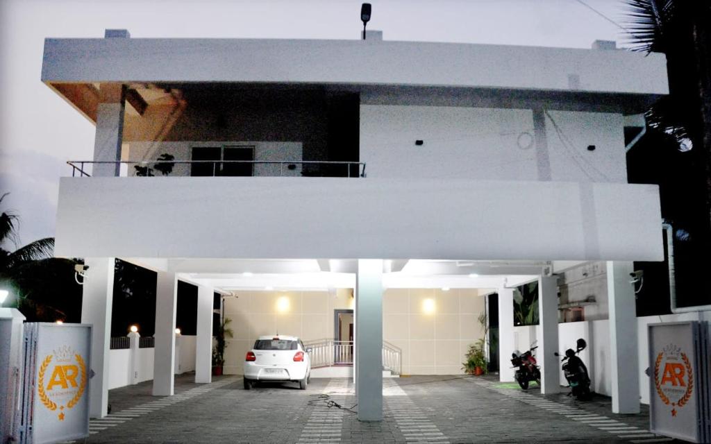 a white car parked in front of a building at Marari A R Residency in Mararikulam