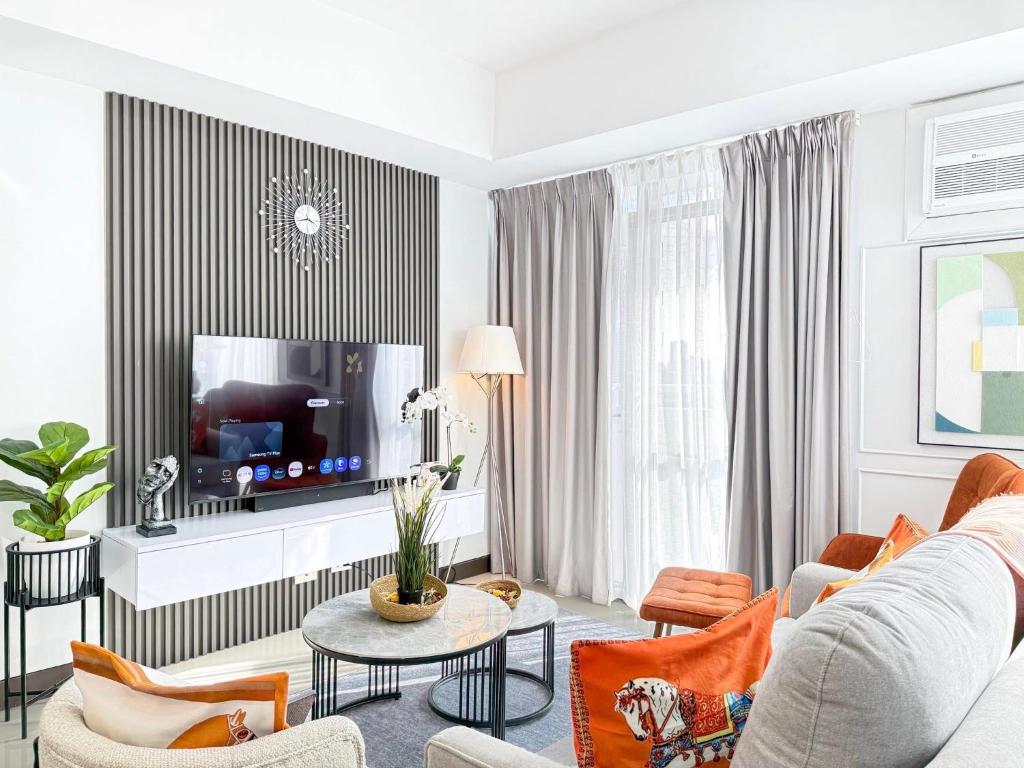 ein Wohnzimmer mit Sofa und Fernseher in der Unterkunft The Apartment in Sampong