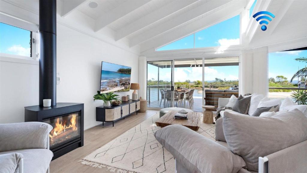 a living room with a couch and a fireplace at Warrahwillah in Currarong