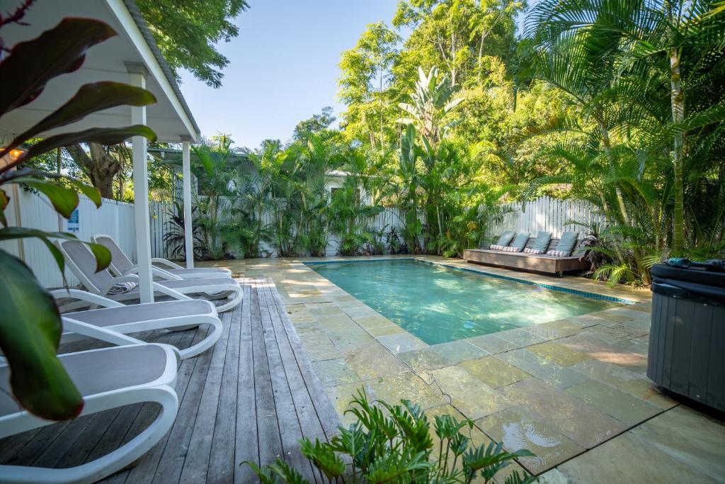 a swimming pool with lounge chairs next to a house at Vihara - Stunning, Private apartment with private pool in Mullumbimby