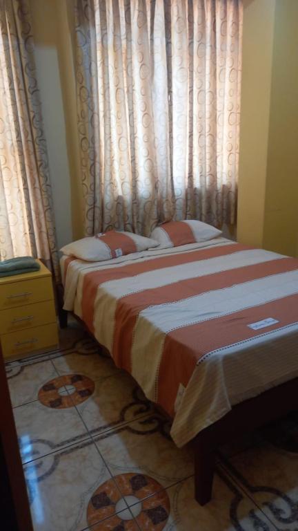 a bedroom with two beds and a window with curtains at Hotel Prince in Barranca