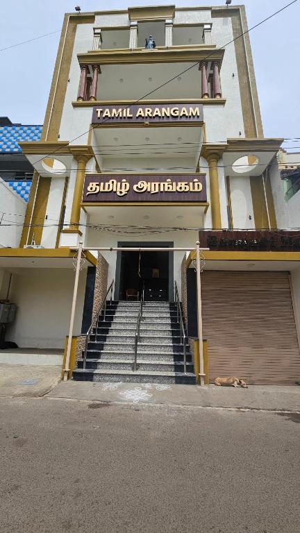 a building with stairs and a sign on it at Tamil Arangam in Kumbakonam