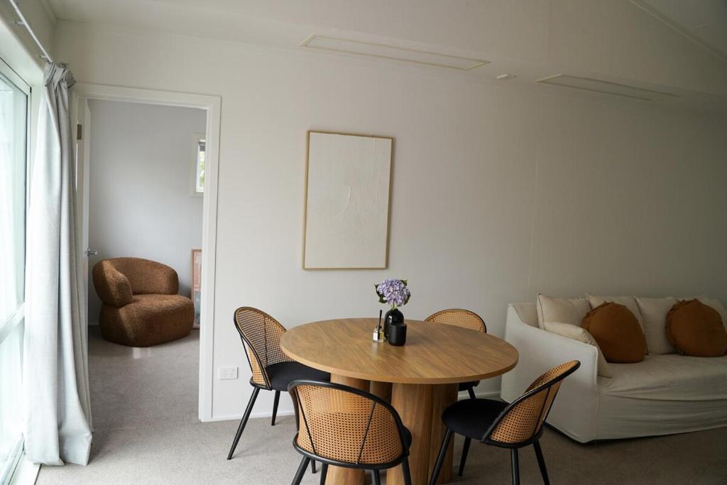 a living room with a table and chairs and a couch at Mapua Village Modern Studio in Mapua