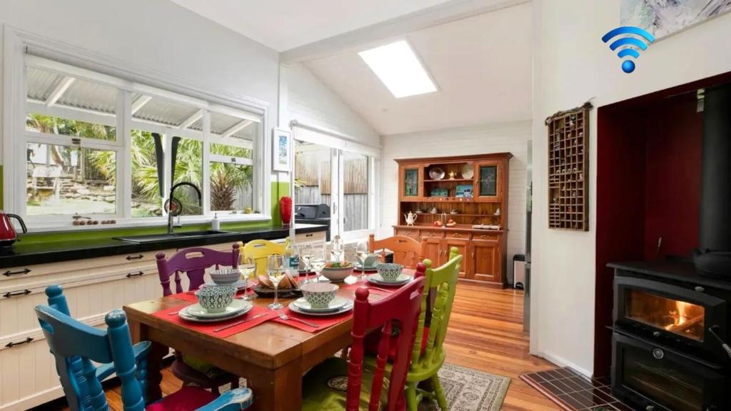 a dining room with a table and chairs in a kitchen at Lilly Pilly Arthouse in Stanwell Park