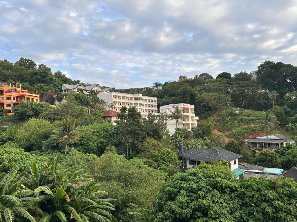 a group of buildings on a hill with trees at Big Apartament with two bedrooms Karon in Phuket