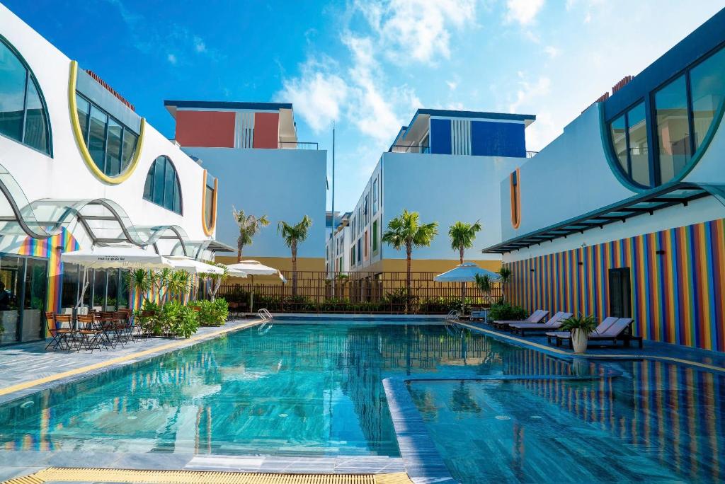 a swimming pool in front of a building at Coast Pearl Hotel in Phú Quốc