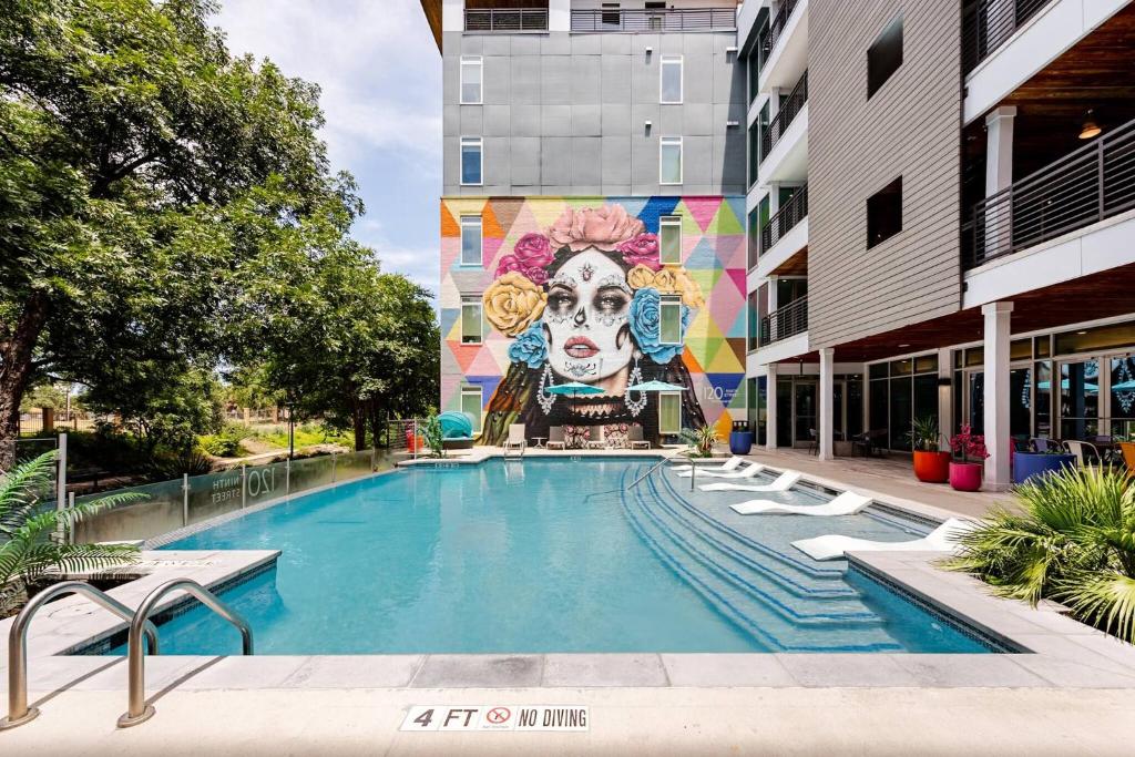 a swimming pool with a mural on the side of a building at Riverwalk Pool View Condo Pets Free Parking in San Antonio