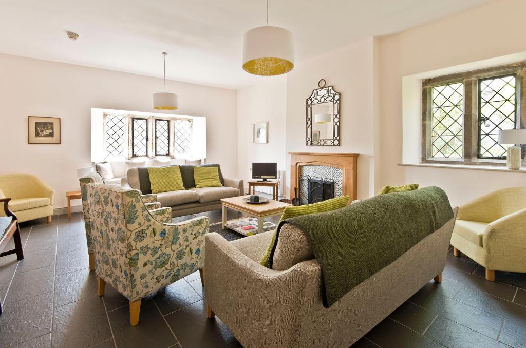 a living room with couches and chairs and a fireplace at Swarthmoor Hall in Ulverston