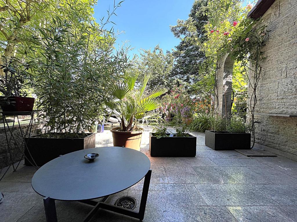 a table and chairs in a courtyard with plants at Garden apartment in Ettlingen