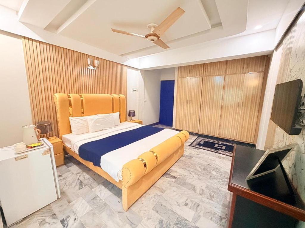 a bedroom with a bed and a flat screen tv at Atlas Gold Hotel in Islamabad
