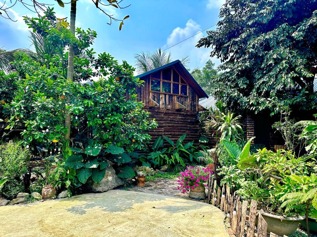 a small wooden cabin in the middle of a garden at Wood Haven Homestay in Ninh Binh
