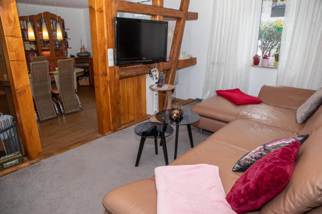 a living room with a couch and a flat screen tv at Ferienhaus im Pochwerksgrund in Suhl Goldlauter im Thüringer Wald in Suhl