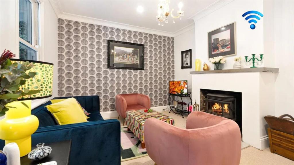 a living room with a couch and chairs and a fireplace at Glenbrae in Bundanoon