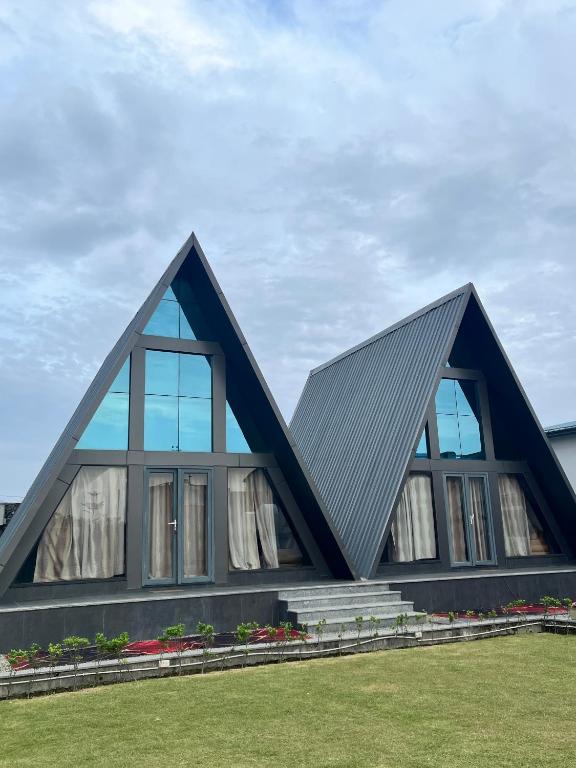 a house with a triangular roof with windows at Lawn Side Manor in Jhājra
