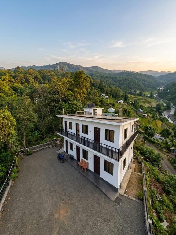 an aerial view of a white house in the mountains at Leaf mountain view holidays rooms in Vagamon
