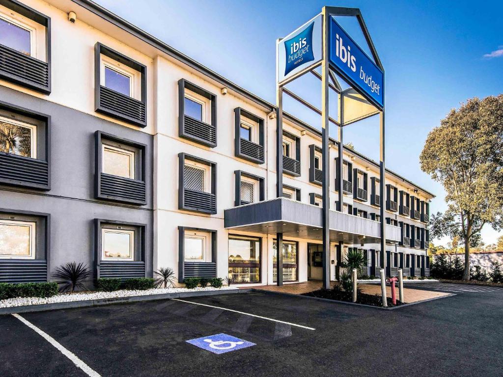 a hotel with a sign in a parking lot at ibis Budget - Campbelltown in Campbelltown