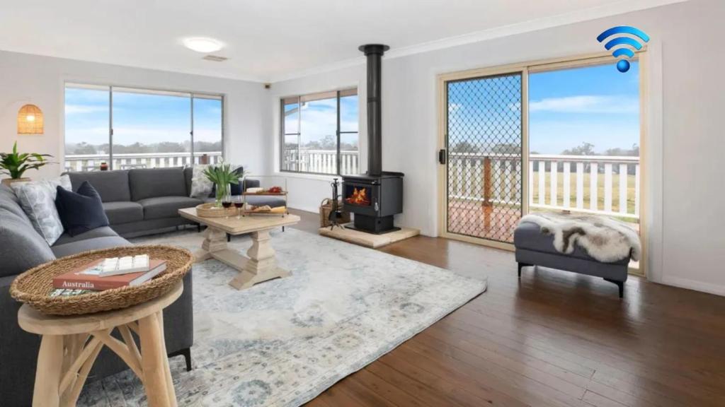 a living room with a couch and a fireplace at Hillside Farm in Mittagong
