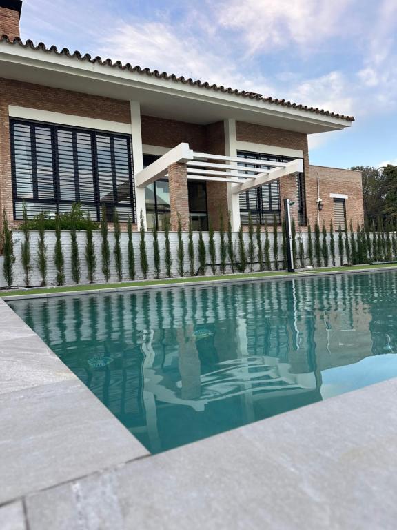 a house with a swimming pool in front of a house at El Puente de Sansueña in Córdoba