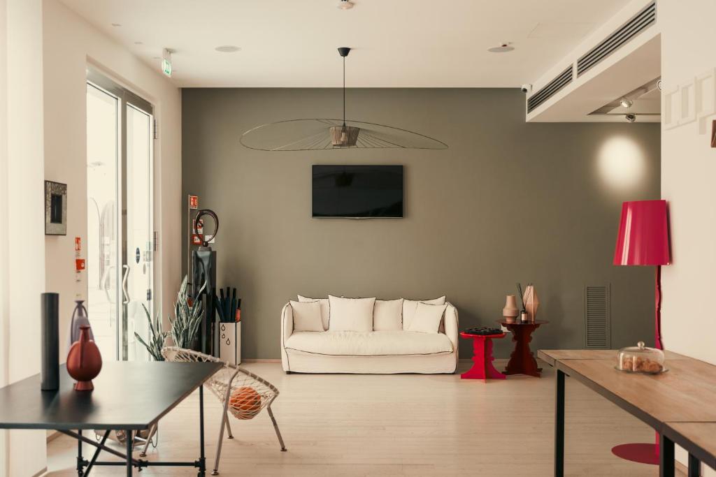 a living room with a white couch and a table at Copacabana Hotel Design in Margherita di Savoia