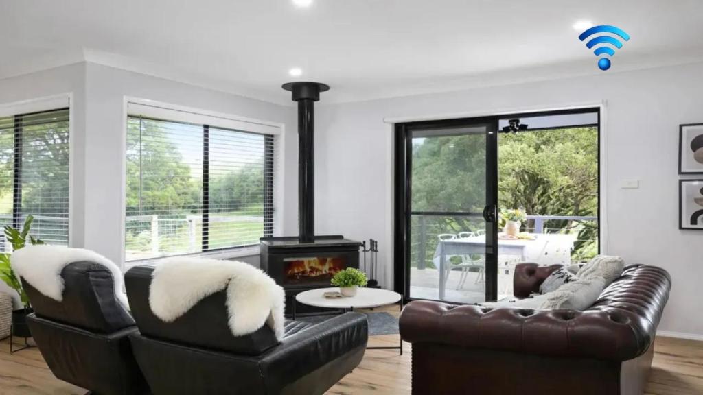 a living room with a leather couch and a fireplace at Hoddle Lane in Robertson