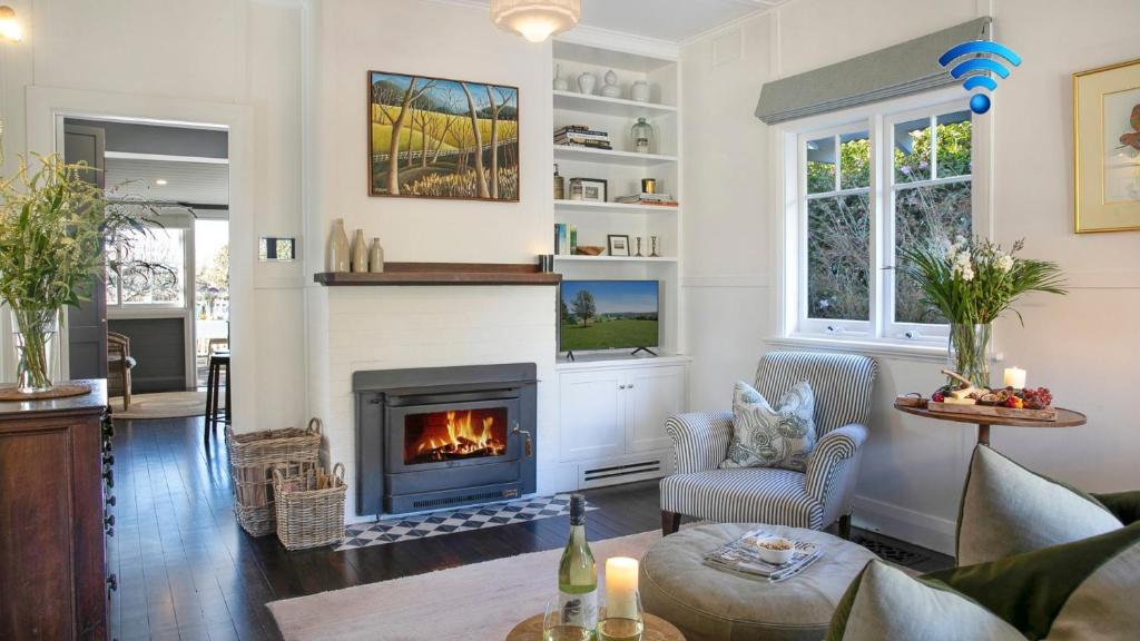 a living room with a fireplace at Werona Cottage - enchanting home in Burrawang