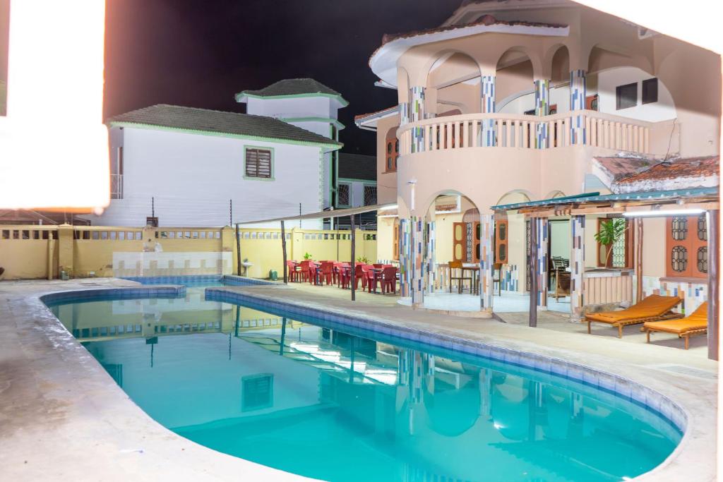 a swimming pool in front of a house at Swahili Social House in Mombasa